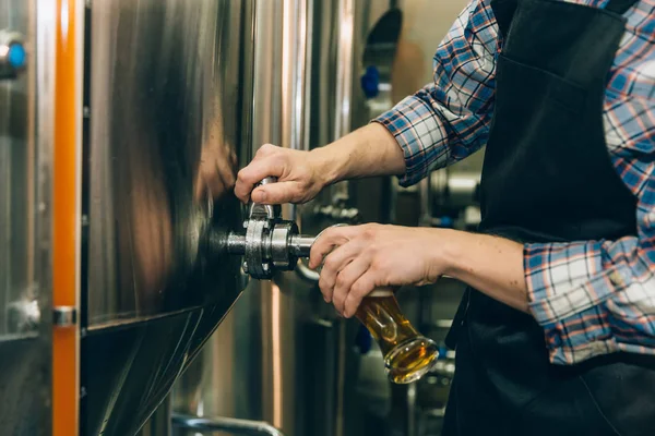 Cervecera llenando cerveza en vidrio del tanque de la cervecería. Concepto de empresa familiar . —  Fotos de Stock