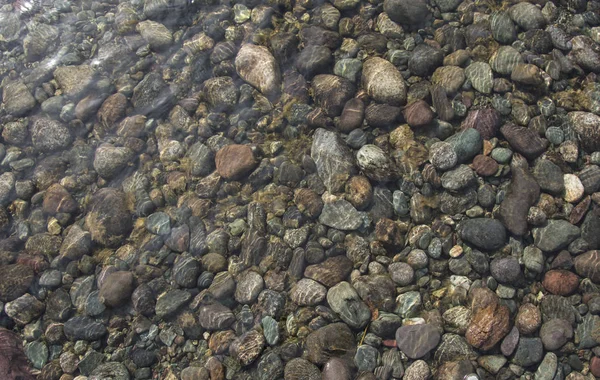 Hintergrund aus Steinen. Kieselsteine unter Wasser. Steinbeschaffenheit — Stockfoto