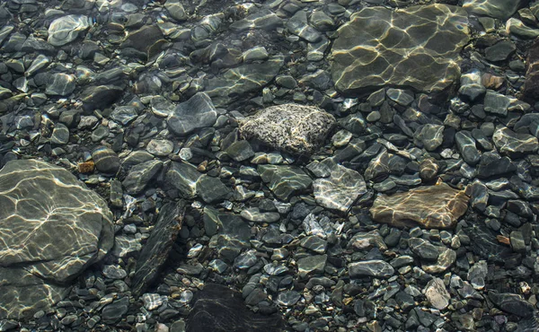 Hintergrund aus Steinen. Kieselsteine unter Wasser. Steinbeschaffenheit — Stockfoto
