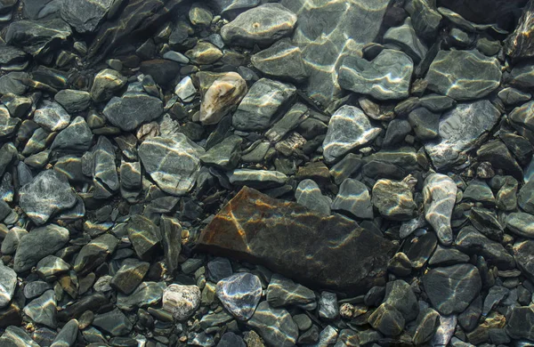 Hintergrund aus Steinen. Kieselsteine unter Wasser. Steinbeschaffenheit — Stockfoto
