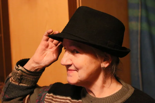happy old lady in black hat in twilight