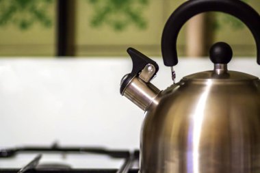 Metal su ısıtıcı Açık Mutfak gaz sobası, parlak metal su ısıtıcısı bir siyah plastik saplı bir parçası ve düdük gaz sobası 