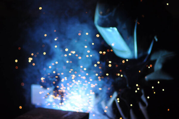 worker welder welds steelworks at the factory