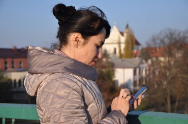 Sonbahar şehrin arka plan telefonda konuşurken güzel genç kız