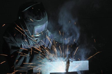 Kaynakçı Kaynak metali üretiminde. Kıvılcım sinek, duman