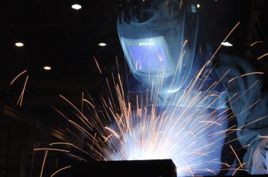 Kaynakçı Kaynak metali üretiminde. Kıvılcım sinek, duman