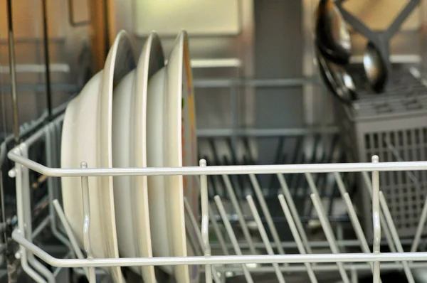 Άνοιγμα πλυντηρίου πιάτων με καθαρά πιάτα στη λευκή κουζίνα — Φωτογραφία Αρχείου