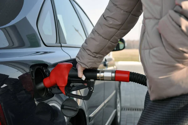 Töltse ki az autót üzemanyaggal. nő egy benzinkútnál, egy bekötést ujj redő az autó — Stock Fotó