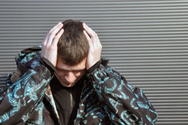 Yakışıklı genç adam. Başını tutarak, baş ağrısı