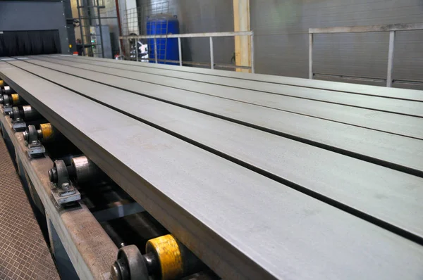 Rollen transporteur voor de levering van metalen producten aan de installatie van zandstralen. — Stockfoto