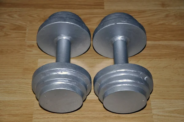 A pair of self-made metal dumbbells on flooring — Stock Photo, Image