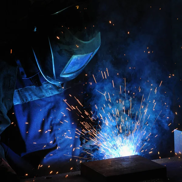 Электросварщик варит сталь на заводе — стоковое фото