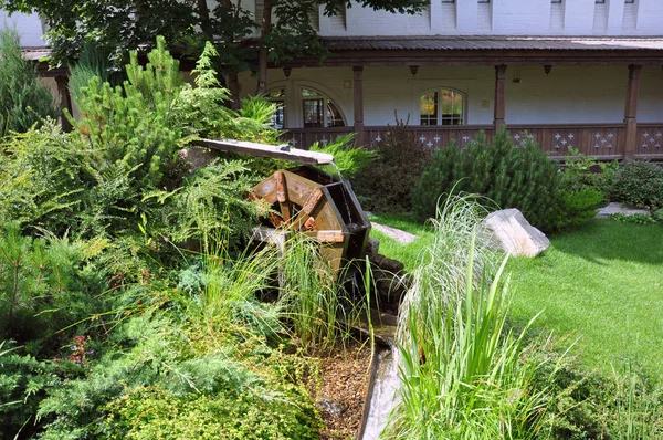 Roda moinho de condução com água caindo no jardim . — Fotografia de Stock