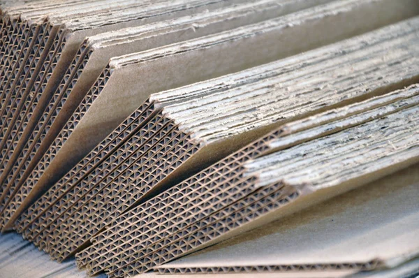 Corrugated cardboard sheets one by one, they are prepared for packing metal structures.