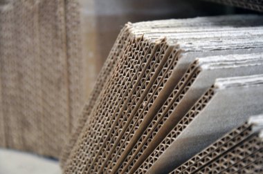 Oluklu mukavva levhalar tek tek, metal yapıların ambalajiçin hazırlanır.