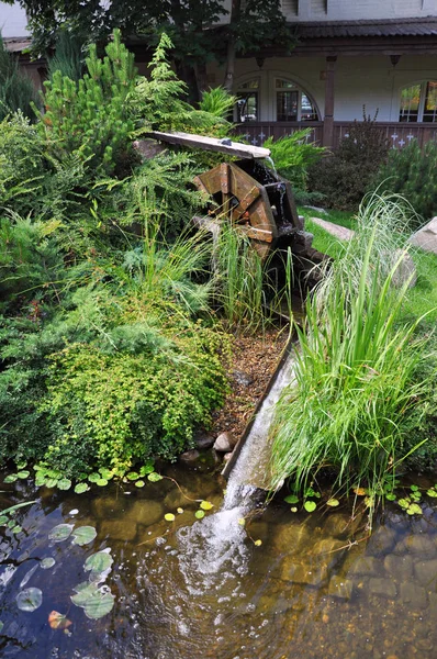 庭に落ちる水と運転ミルホイール. — ストック写真
