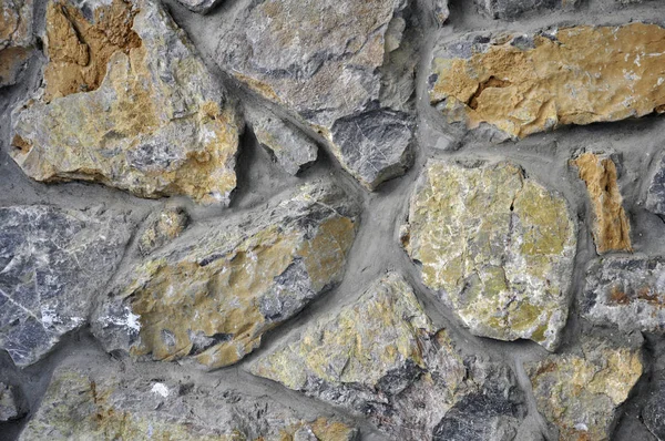 Parede feita de pedra natural com um tom vermelho . — Fotografia de Stock