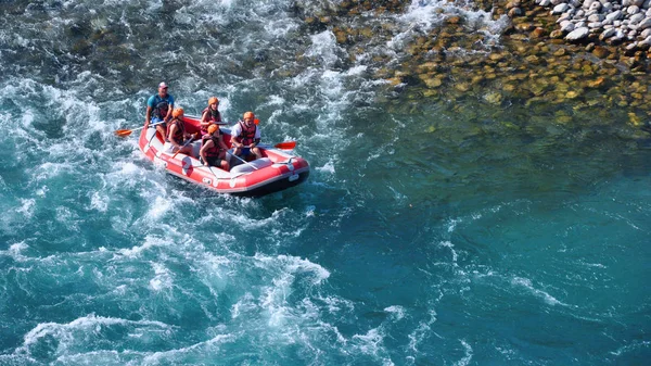 Rafting, un grup de tineri cu un ghid de rafting de-a lungul unui râu de munte. Sportul extrem și distractiv la o atracție turistică . — Fotografie, imagine de stoc