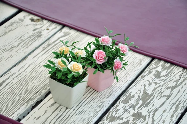 Artificial flowers in pots on the table. — Stock Photo, Image
