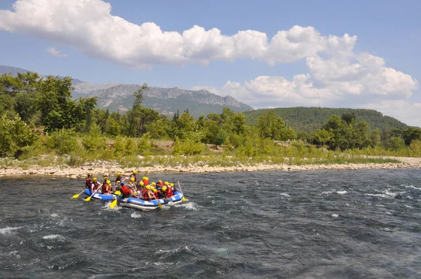 Rafting, un grup de tineri cu un ghid de rafting de-a lungul unui râu de munte. Sportul extrem și distractiv la o atracție turistică . — Fotografie, imagine de stoc