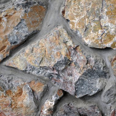 Kırmızı tonlu doğal taştan yapılmış duvar.