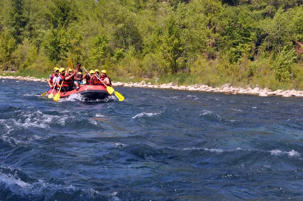 Rafting, um grupo de jovens com um rafting guia ao longo de um rio de montanha. Esporte extremo e divertido em uma atração turística . — Fotografia de Stock