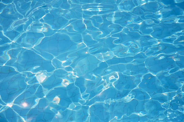 Los cáusticos del fondo de la piscina ondulan y fluyen con el fondo de las olas. Fondo de verano. Textura de la superficie del agua . —  Fotos de Stock