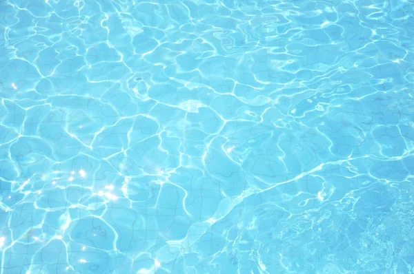 Los cáusticos del fondo de la piscina ondulan y fluyen con el fondo de las olas. Fondo de verano. Textura de la superficie del agua . —  Fotos de Stock