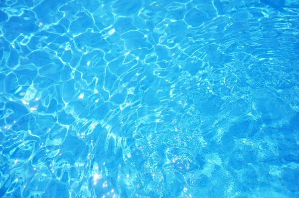 Los cáusticos del fondo de la piscina ondulan y fluyen con el fondo de las olas. Fondo de verano. Textura de la superficie del agua . —  Fotos de Stock