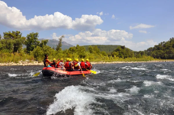 Rafting, un groupe de jeunes avec un guide en rafting le long d'une rivière de montagne. Sport extrême et amusant à une attraction touristique . — Photo