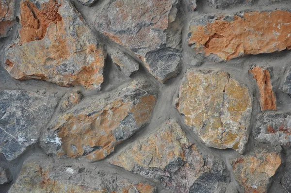 Wand aus Naturstein mit roter Tönung. — Stockfoto