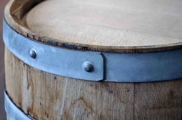 New oak barrel with young wine, cap and rivets.