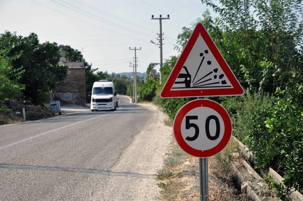 Señal de límite de velocidad en el campo en una noche de verano. El límite de velocidad es de 50 km h en una carretera de tierra . — Foto de Stock