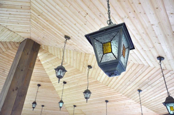 Patio buiten lente tuin in de achtertuin van het huis met een close-up van lantaarns lampen lichten opknoping op de gazebo Arbors houten Arbors. — Stockfoto