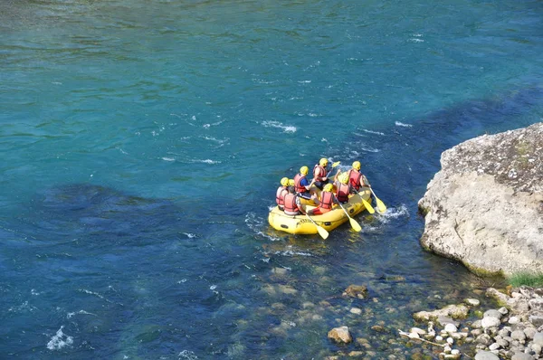 Alanya, Turquia - 18 de agosto de 2019: rafting, um grupo de jovens com guia, rafting em um rio de montanha em um barco. Esportes radicais e divertidos . — Fotografia de Stock