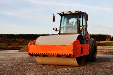 Yol inşaatında turuncu yol silindiri. İnşaat makineleri.