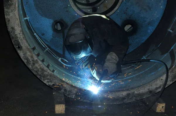 Profesyonel kaynakçı bir atölyede endüstriyel bir tankı kaynaklıyor.. — Stok fotoğraf