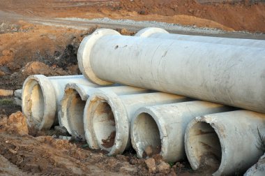 Yerdeki iki sıra çimento ya da beton toprak borusunun geniş açılı görüntüsü kanalizasyon sistemleri ve su kemerleri oluşturmak için kullanılır.