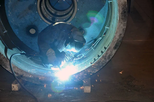 Professional welder welds an industrial tank in a workshop. — Stockfoto
