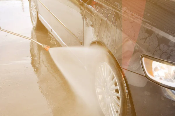 Lavado de coches de verano en un auto-servicio de lavado sin contacto. Limpieza de un coche con agua a alta presión . —  Fotos de Stock
