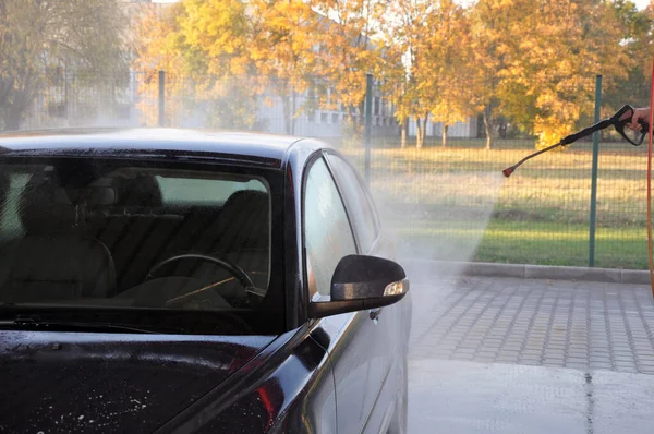 Lavado de coches de verano en un auto-servicio de lavado sin contacto. Limpieza de un coche con agua a alta presión . —  Fotos de Stock