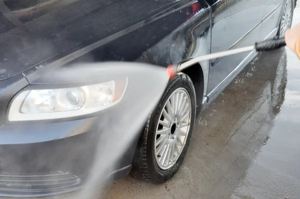 Lavado de coches de verano en un auto-servicio de lavado sin contacto. Limpieza de un coche con agua a alta presión . —  Fotos de Stock