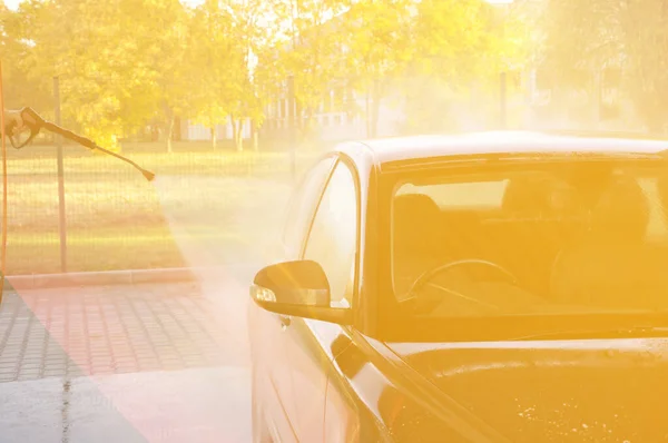 Lavagem de carro de verão em uma lavagem de carro self-service sem contato. Limpeza de um carro usando água de alta pressão . — Fotografia de Stock