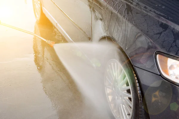 Lavagem de carro de verão em uma lavagem de carro self-service sem contato. Limpeza de um carro usando água de alta pressão . — Fotografia de Stock