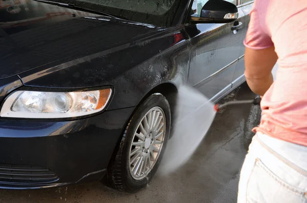 Lavado de coches de verano en un auto-servicio de lavado sin contacto. Limpieza de un coche con agua a alta presión . —  Fotos de Stock