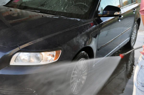 Sommar biltvätt på en kontaktlös självbetjäning biltvätt. Rengöring av en bil med högtrycksvatten. — Stockfoto