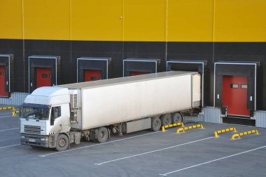 Modern bir depo kompleksinde kamyonlar boşaltılıyor..