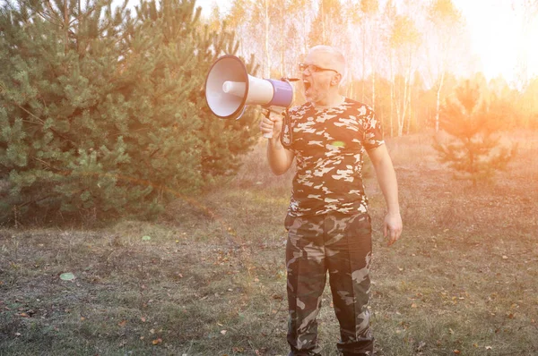 Portret młodego mężczyzny krzyczącego z megafonem w lesie. Koncepcja wyszukiwania zaginionych ludzi — Zdjęcie stockowe