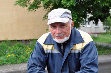 Şehrin dinlenme alanının arka planında kepli zeki sakallı bir adamın portresi..