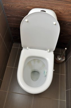 Sifon suyunda pas izleri olan beyaz bir tuvalet. Hijyen Temizliği